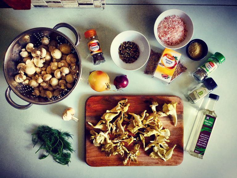 Ingredients for pickled mushrooms: button and shiitake mushrooms, onions, garlic, dill, vinegar and pickling spices