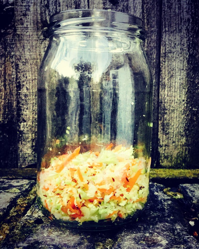 Salted cabbage and carrot at the bottom of a glass jar