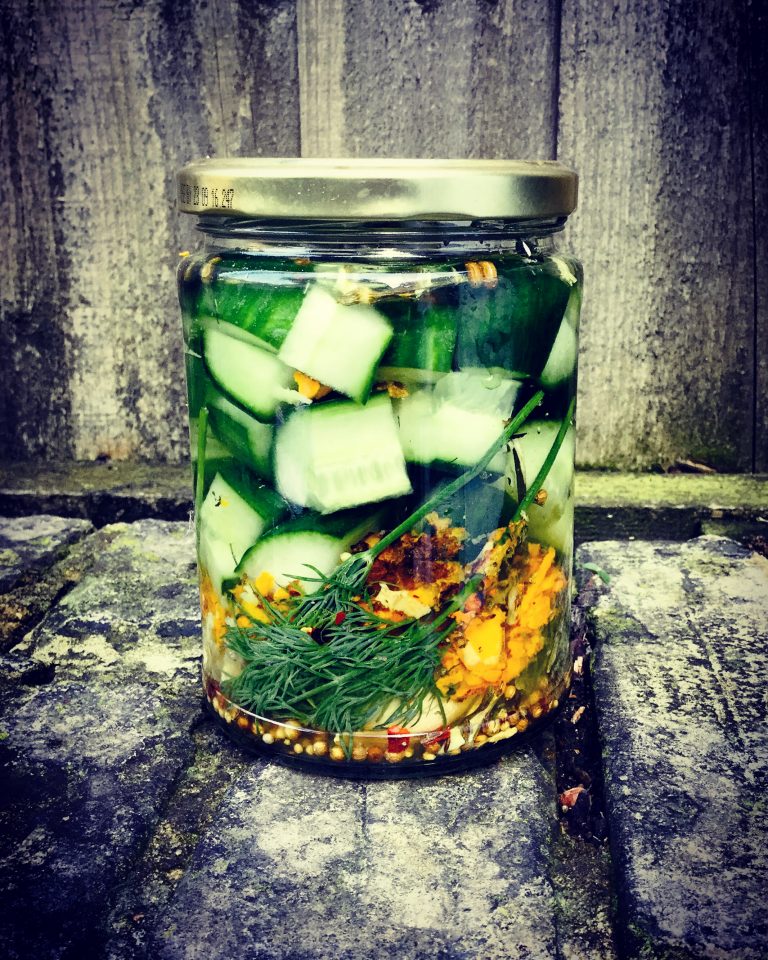 A smaller jar of cucumber chunks with dill, chili, turmeric and mustard seeds